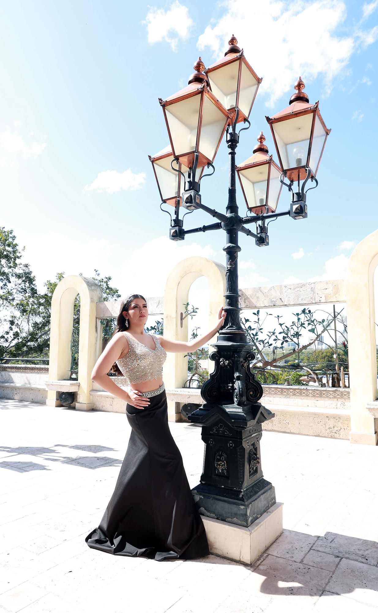 Quinceanera wearing a black dress with gold detailing representing sophistication and strength