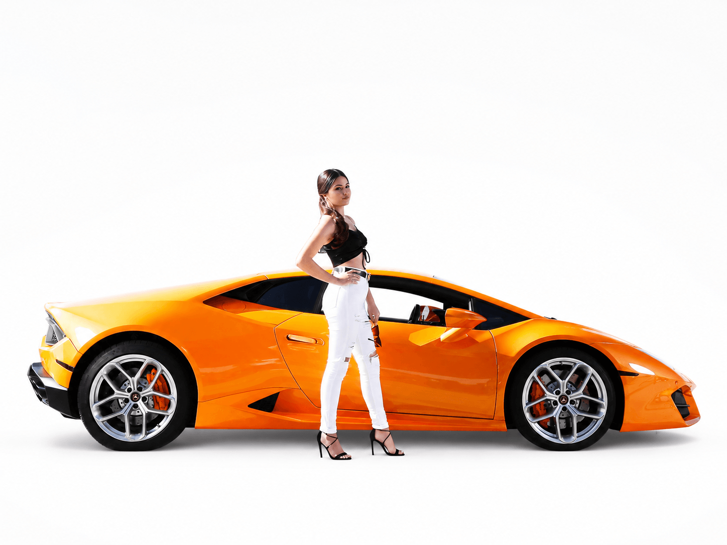 Quinceanera in an orange dress posing next to a luxury sports car representing warmth and creativity
